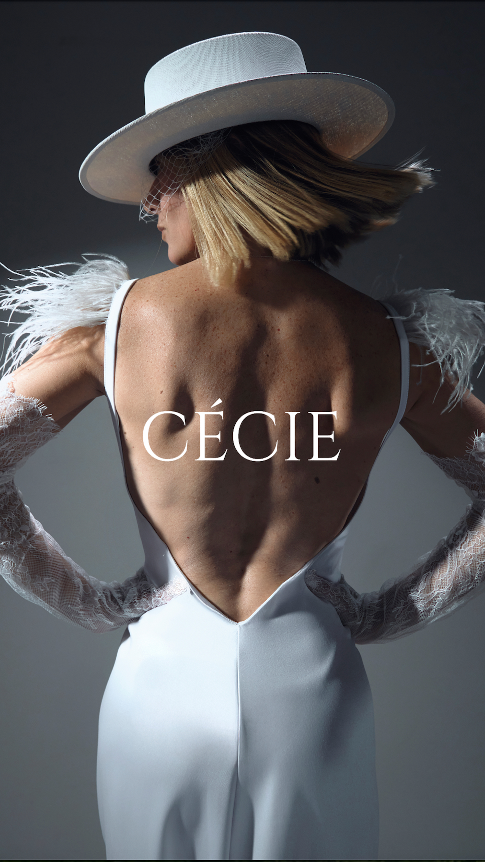 Person wearing a white outfit with feathered sleeves and a hat, back view, on a dark background with 'Cécie' branding.