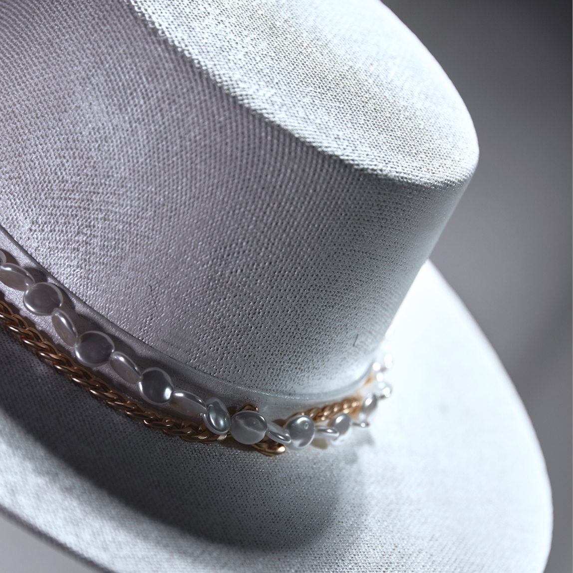 Close-up of a white hat with decorative band on a blurred background